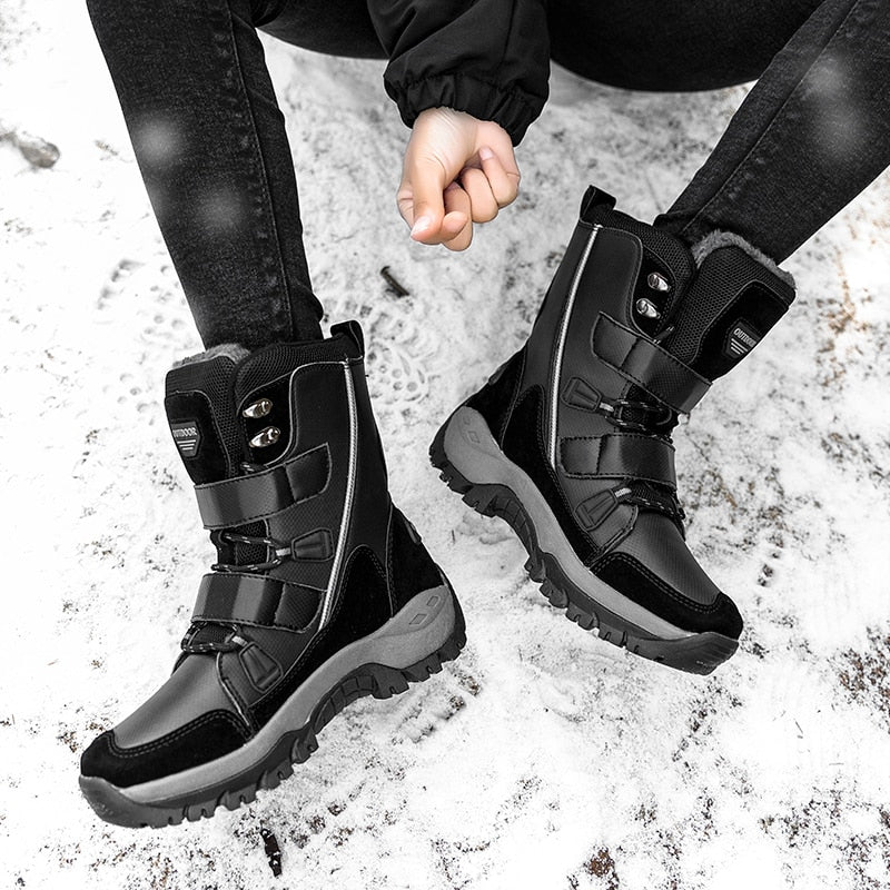 HexoComfy™ high-top winter boots in Black with hook-and-loop straps on a snowy path